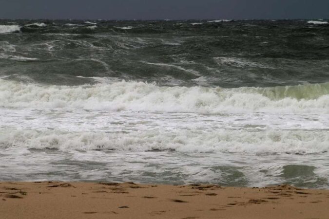 Des vagues tumultueuses s'écrasent sur une plage de sable, amplifiant le bruit des vagues par temps agité.